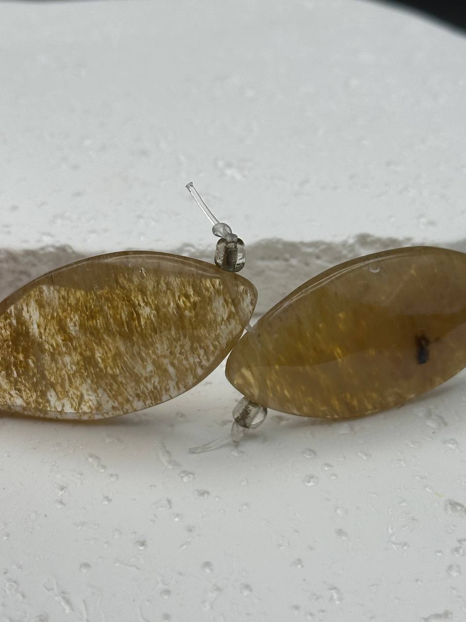 Amber oval beads on a light gray surface
