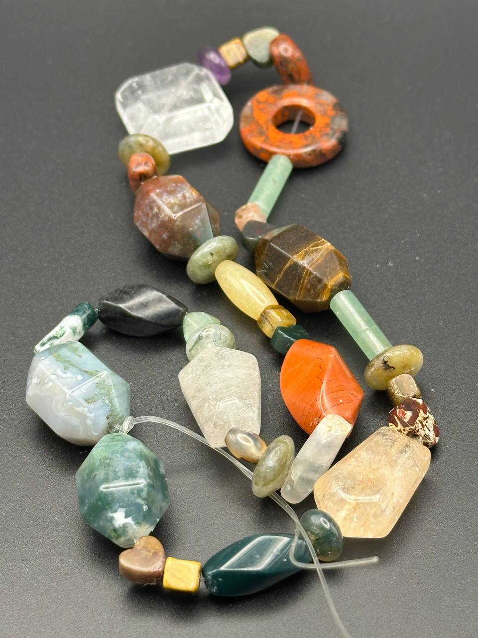 Colorful beaded necklace on a dark gray background