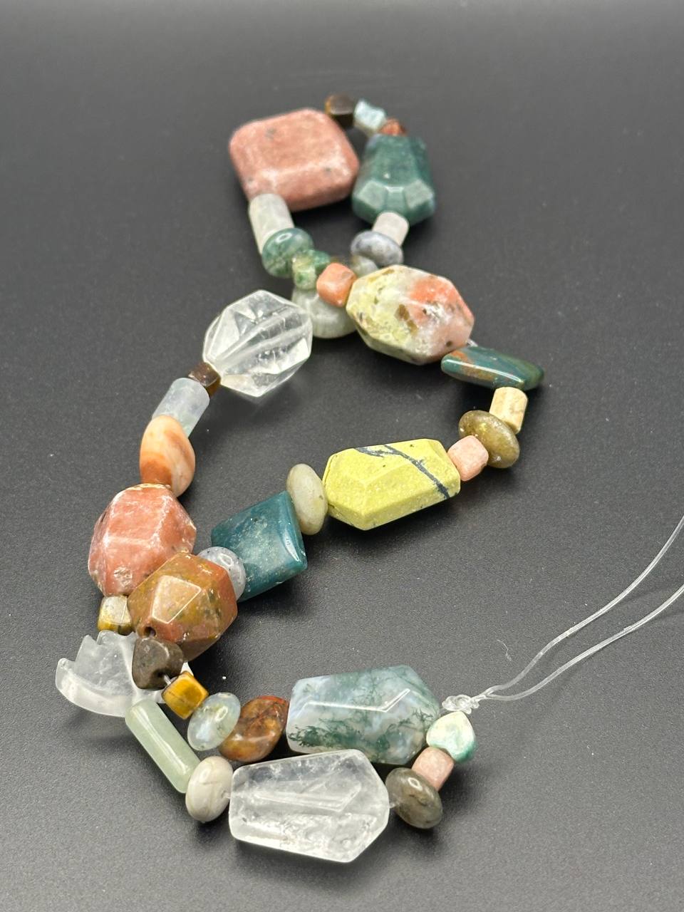 Necklace with multicolored beads on a gray background