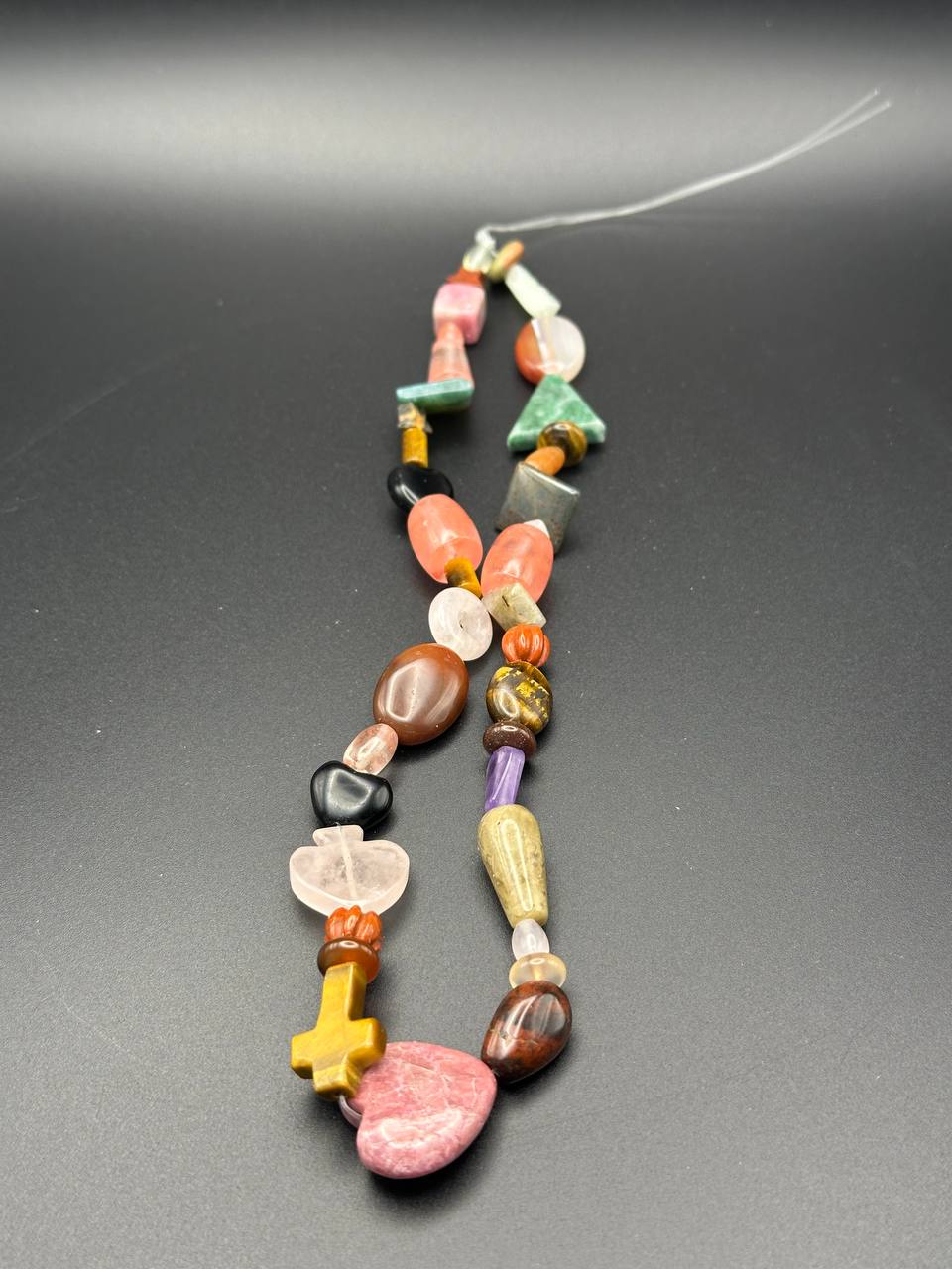 Necklace with multicolored beads on a gray background