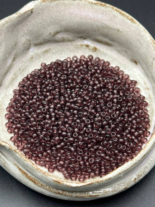 Close-up of small purple beads in a ceramic container