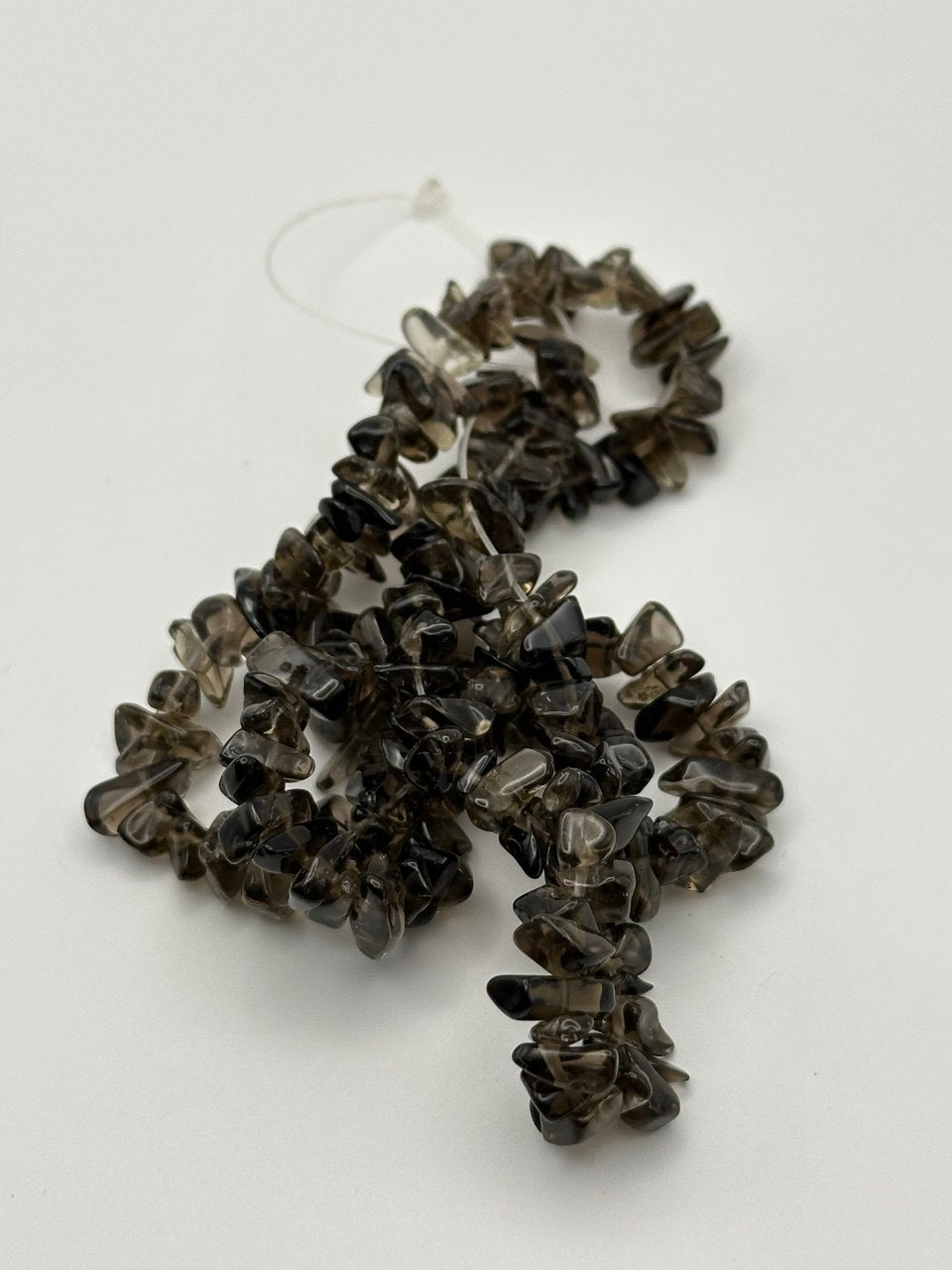 brown to black small smoky quartz chip beads on a white surface