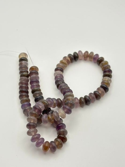 Strand of multicolored auralite beads on a white background