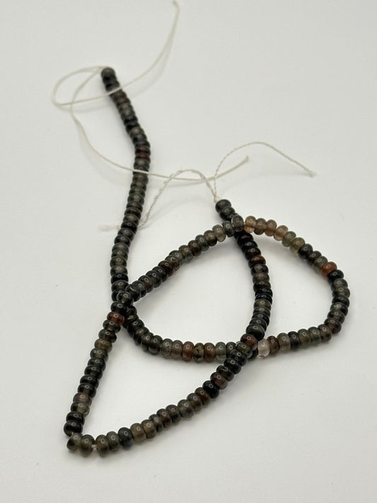 String of dark beads on a white background