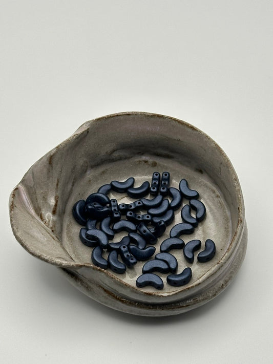 Ceramic dish with dark blue arcos par puca on a white background