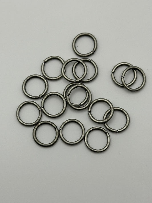 Collection of silver metal jump rings on a gray background