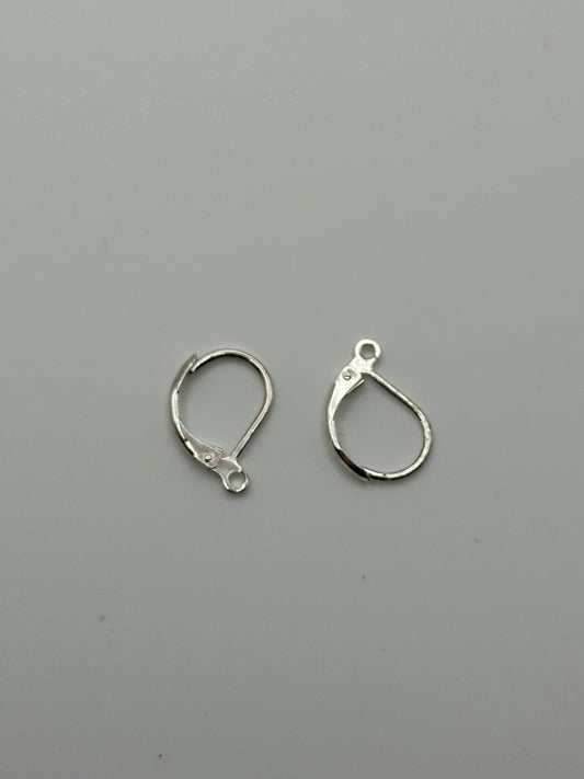 Silver plated leverback earring on grey surface