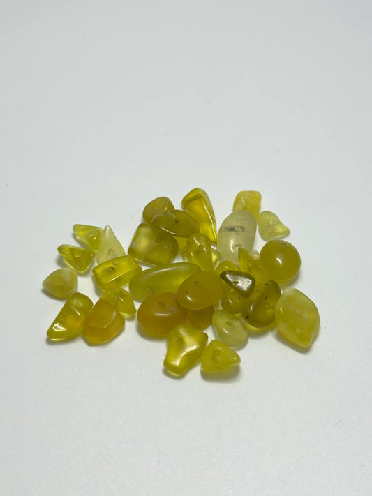 A small pile of olive opal irregular chip beads on white background