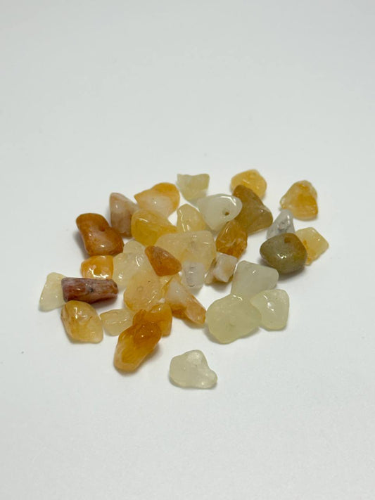 A small pile of citrine irregular chip beads on white background