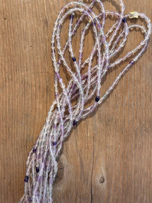 Amethyst tumbled beads on wooden surface