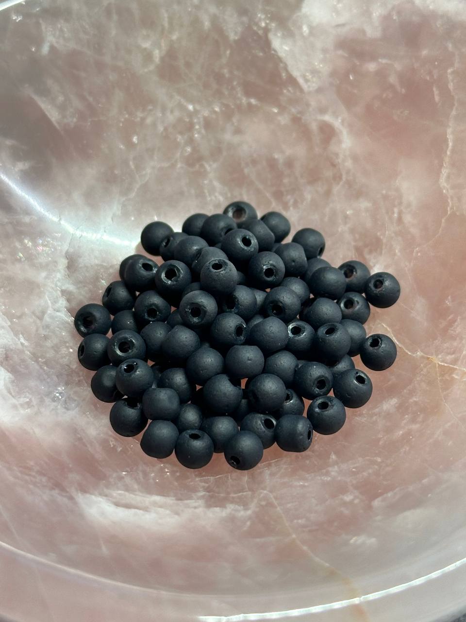 Black beads on a textured pink surface