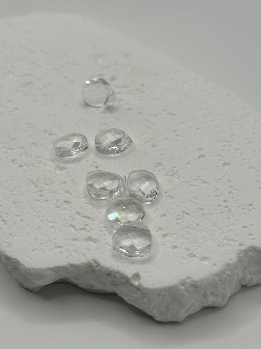 Clear crystal briolettes on a textured white surface