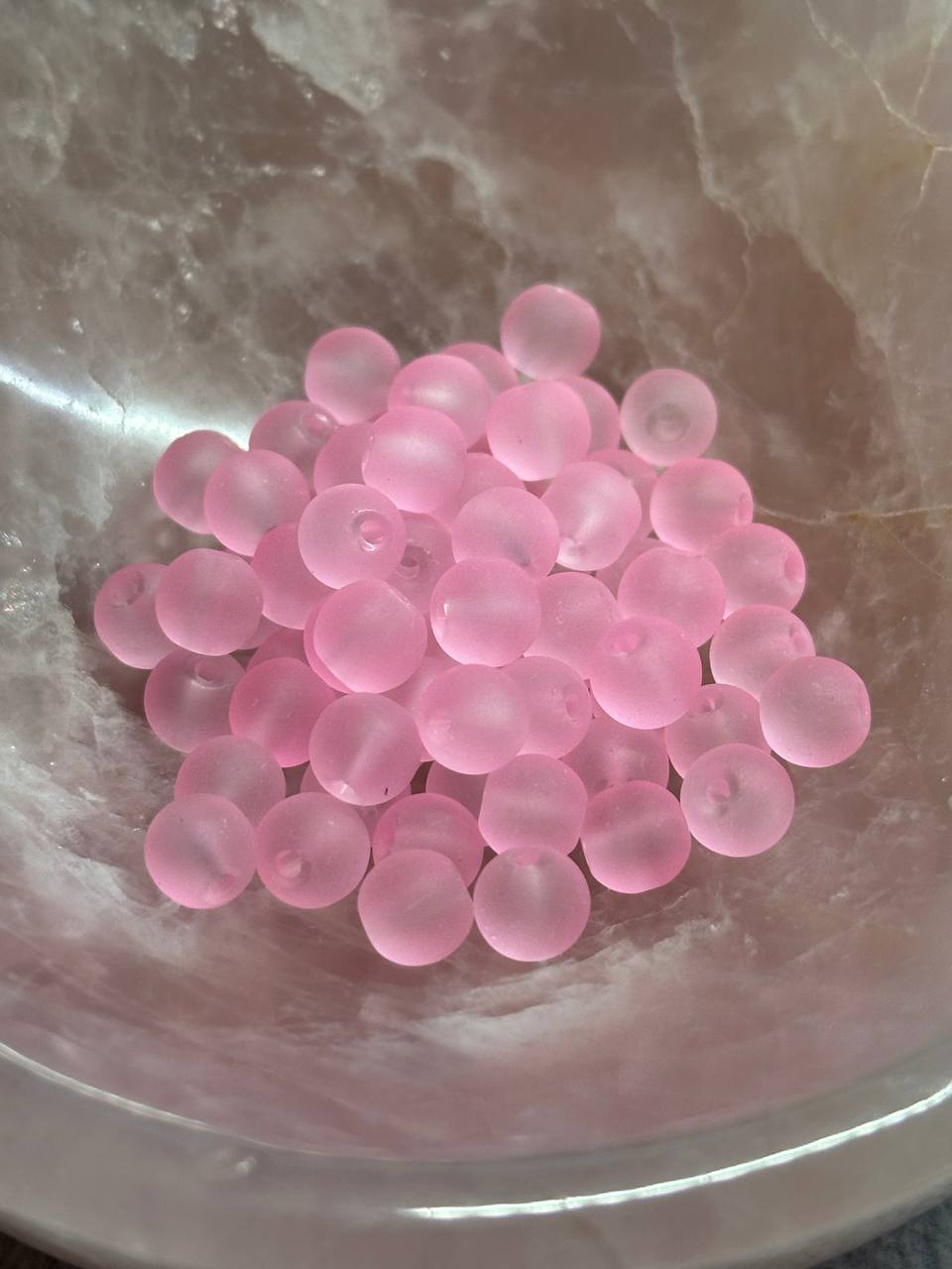Pink beads on a reflective surface