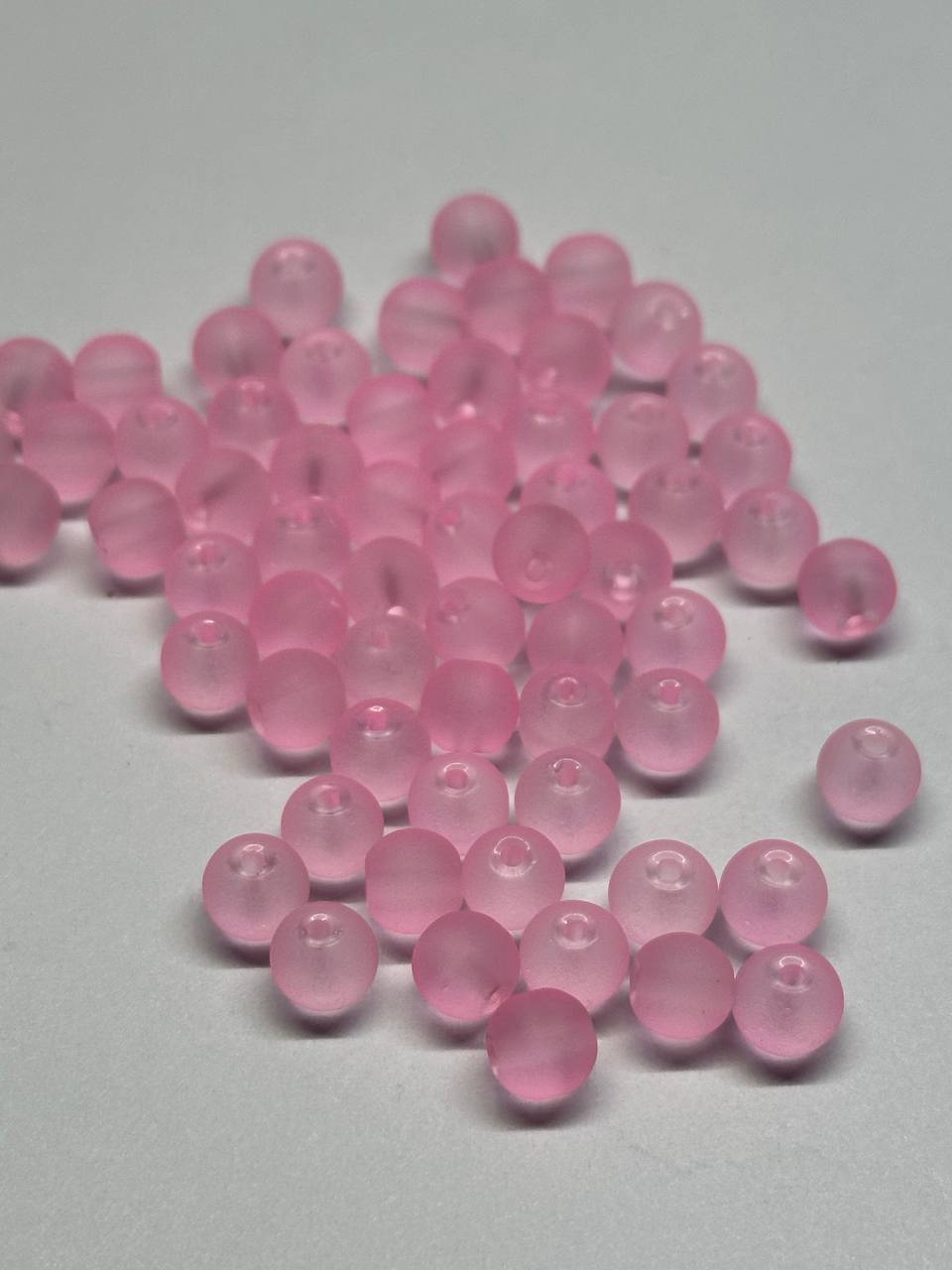 Pink beads scattered on a gray surface