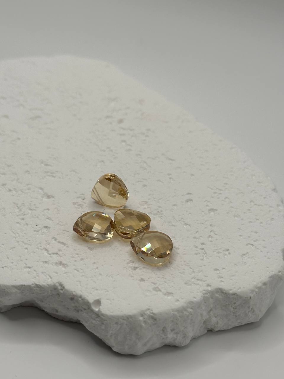 Golden Shadow crystal briolettes on white surface