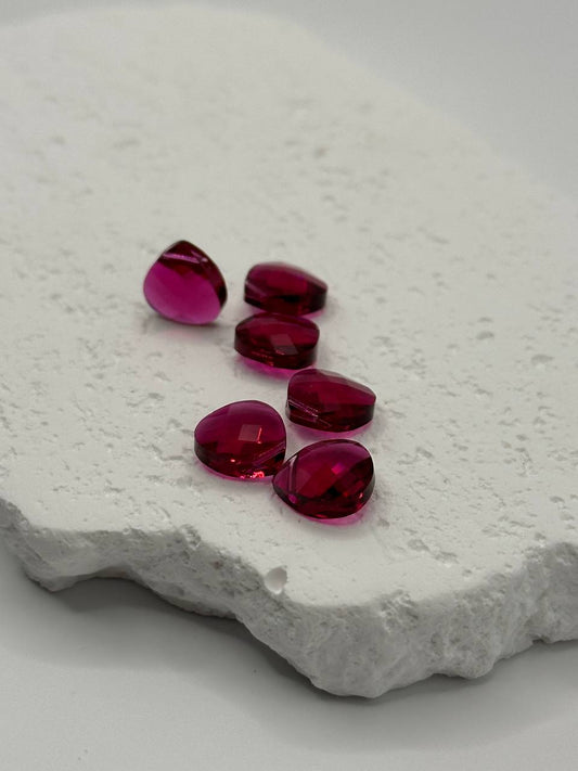 Ruby crystal beads on a textured white surface