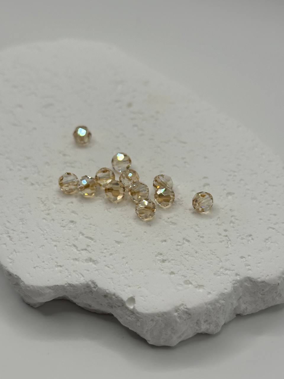 Golden shadow faceted round beads on white surface