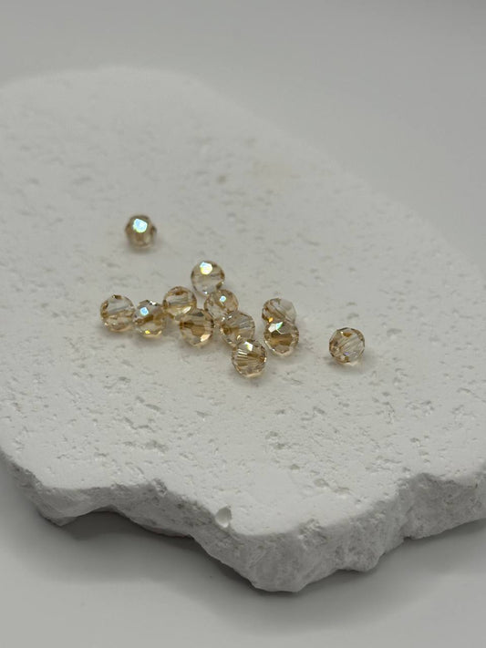 Golden shadow faceted round beads on white surface