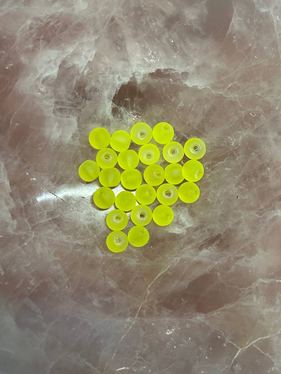 Group of lime circular beads on a marbled surface