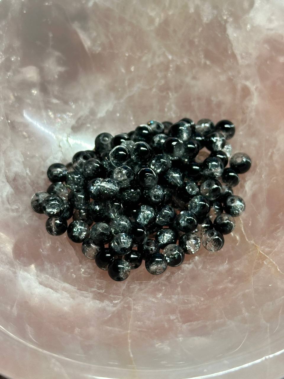 Black beads on a translucent pink stone