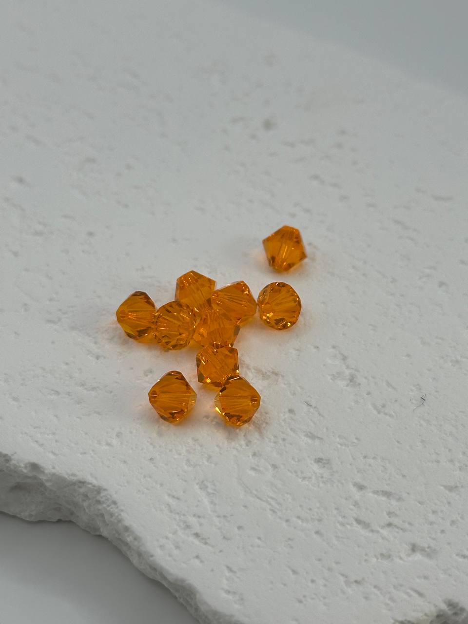 Sun bicone beads on white surface