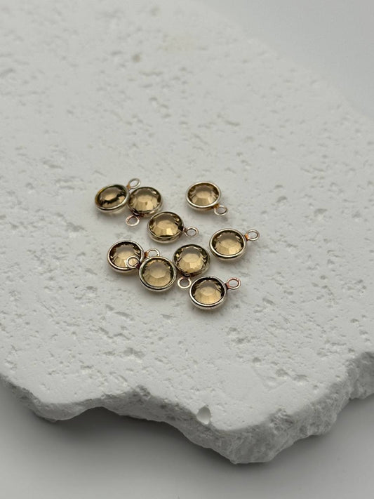 Gold jewelry components on a textured white surface