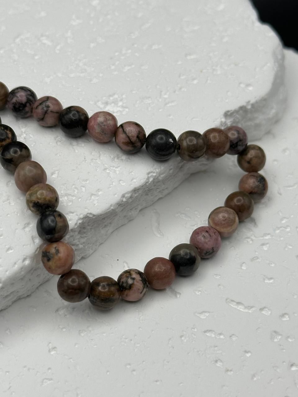 Rhodonite beads on white surface