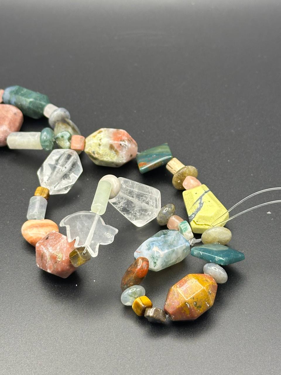 Necklace with multicolored beads on a gray background