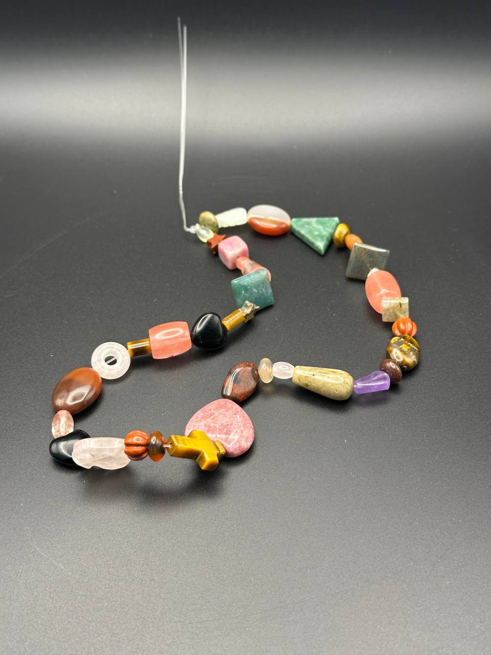 Colorful beaded necklace on a gray background
