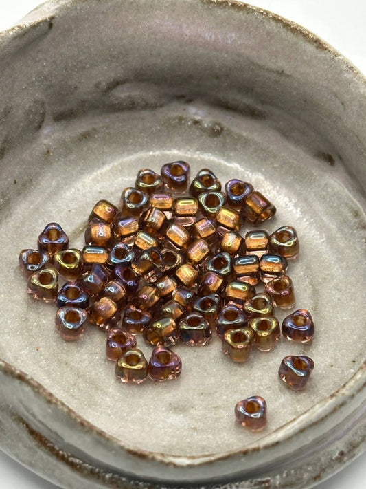 Small triangle glass beads in a metallic finish on a textured surface