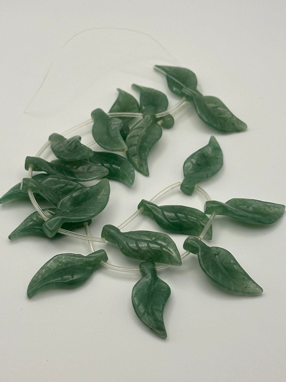 aventurine leaf shaped beads on grey background