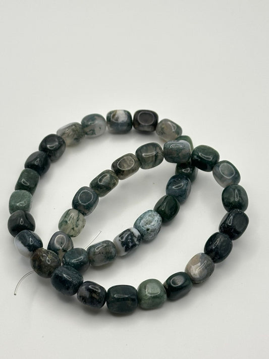 A string of moss agate rectangular bead on a white surface