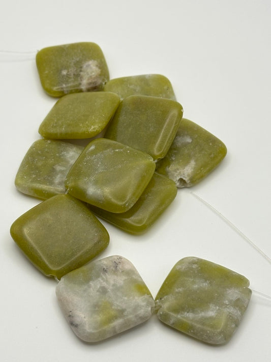 Olive green serpentine puffed chunky square slabs on a white surface
