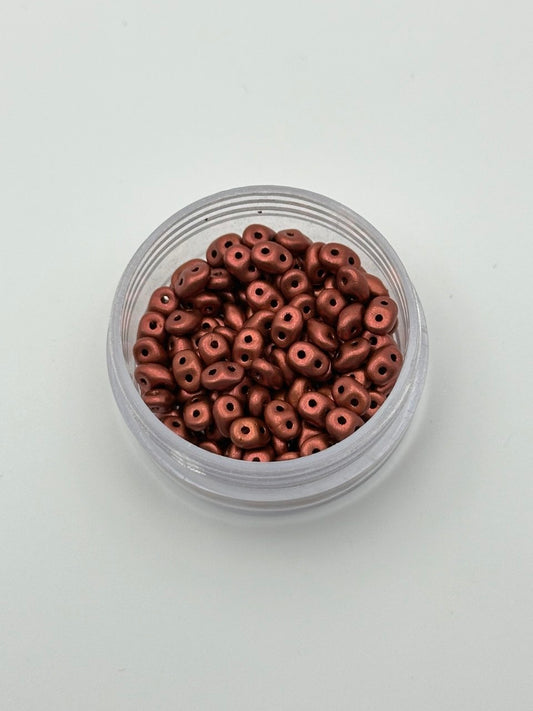 Jar of small metallic beads on a light gray background
