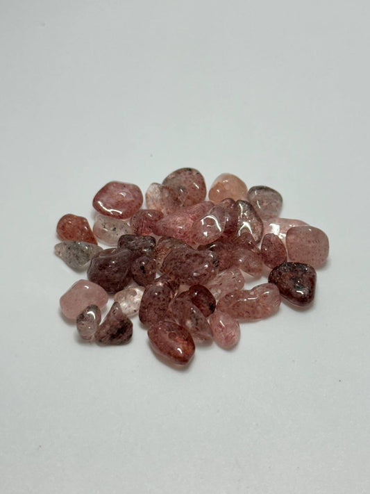 A small pile of strawberry quartz chip beads on white background