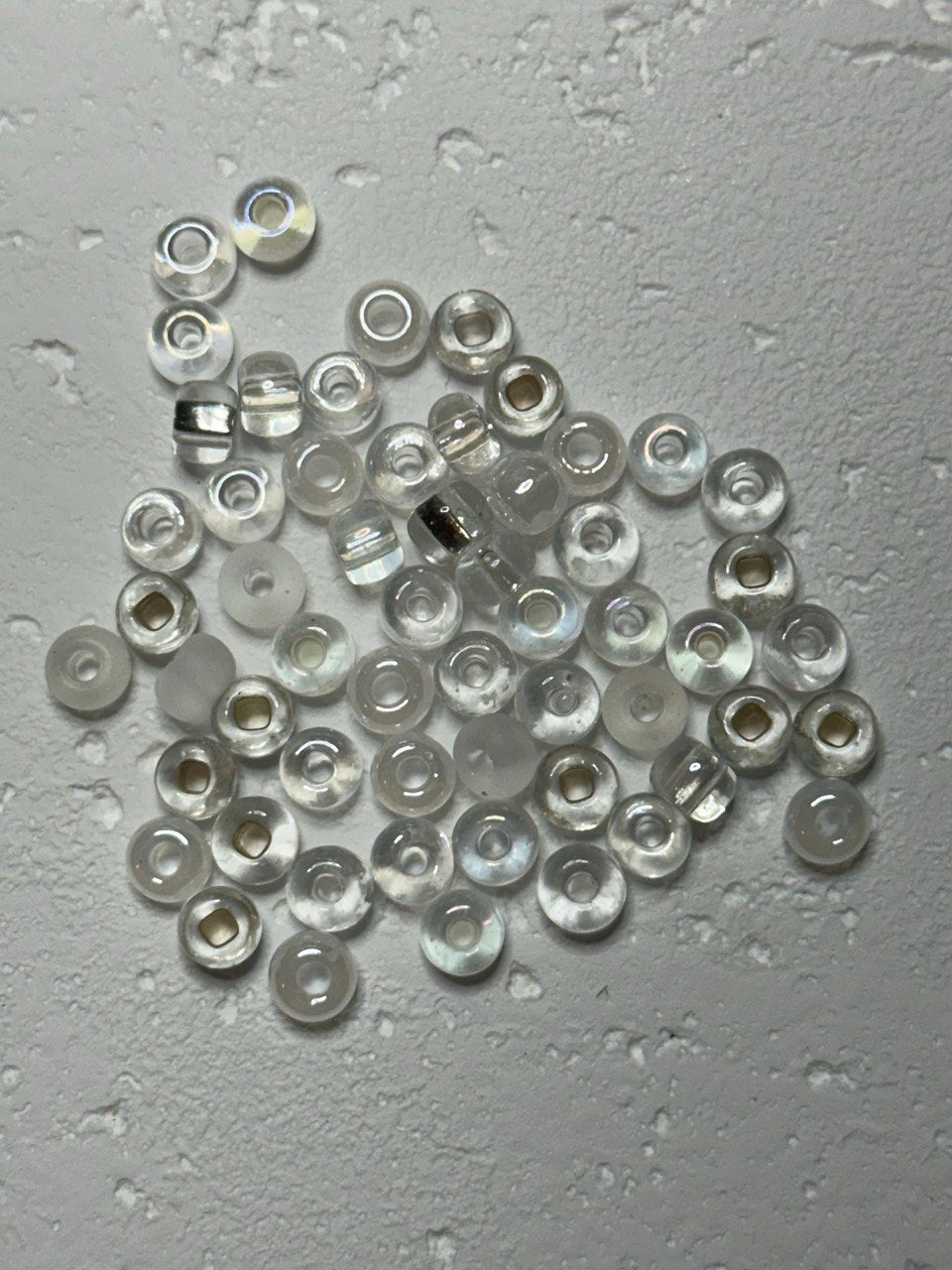 a small pile of crystal white mix e beads in size 2 on white surface