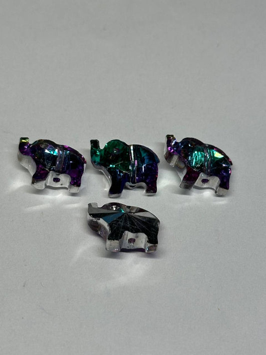 Four multicolored elephant-shaped beads on a light gray background