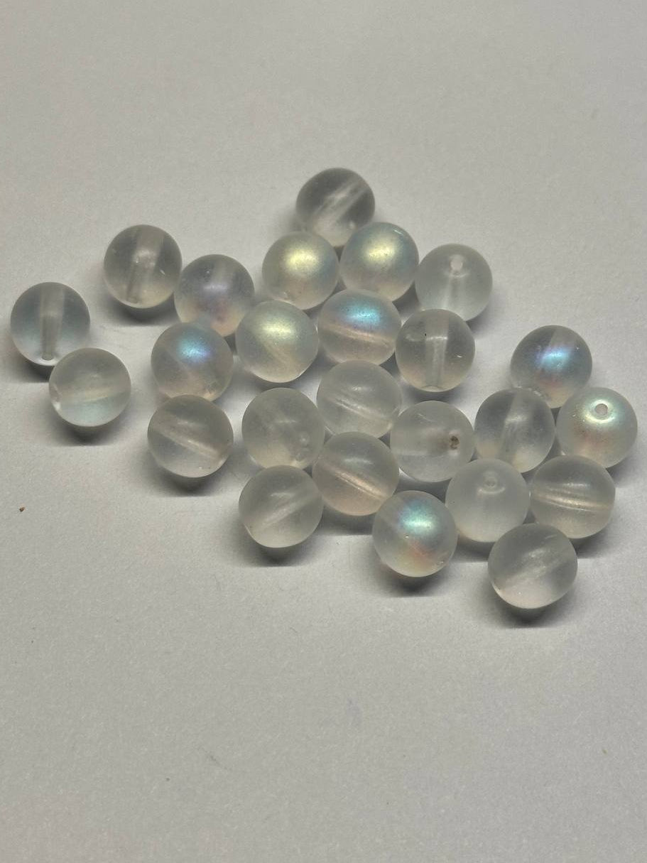Set of white beads with rainbow-like reflections on a gray background
