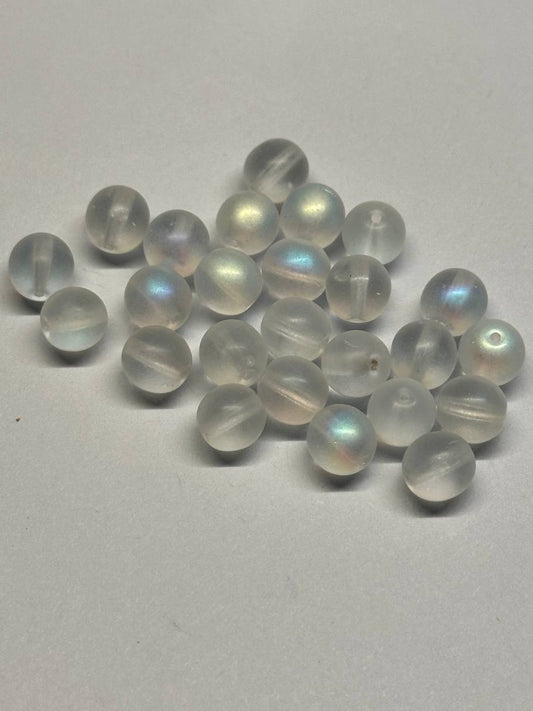 Set of white beads with rainbow-like reflections on a gray background