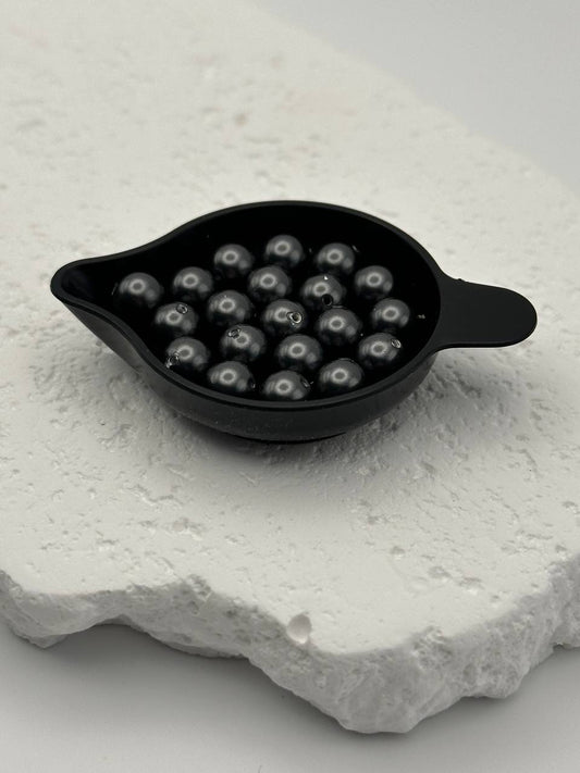 Black crystal pearls on white surface