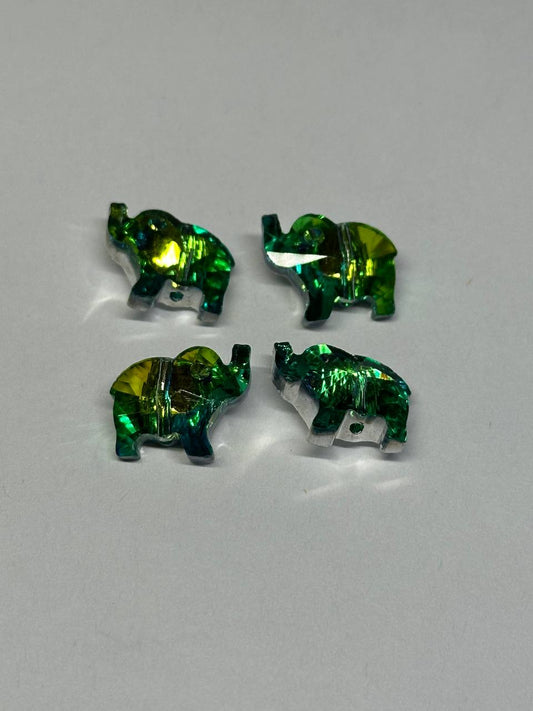 Four green elephant-shaped rhinestones on a gray background