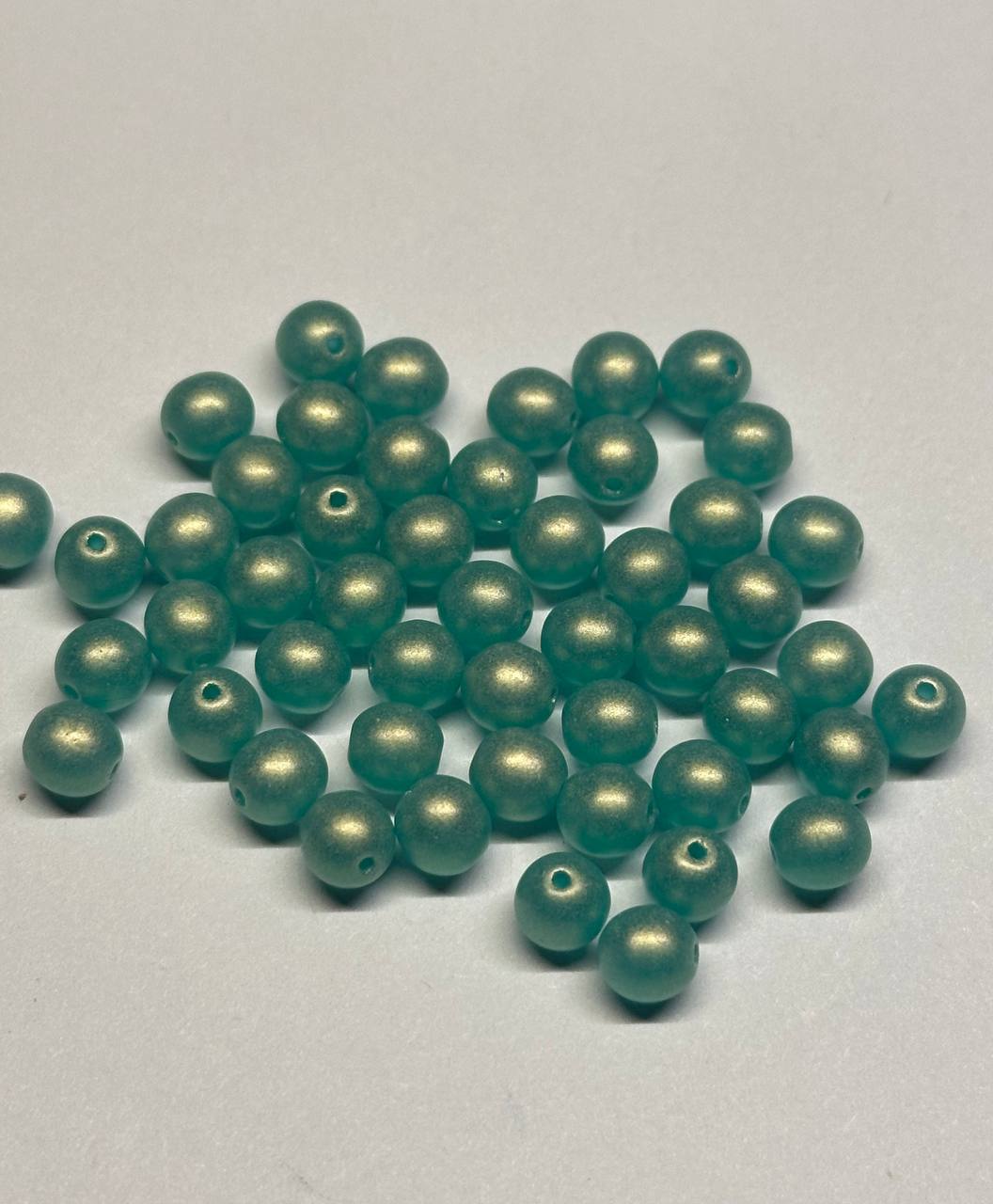 Teal beads on a light gray background