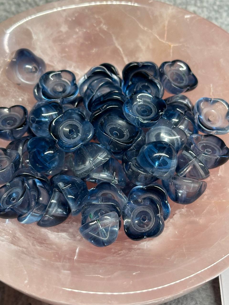 Blue bead caps on a pink surface