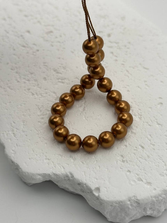 Copper crystal pearls on white surface