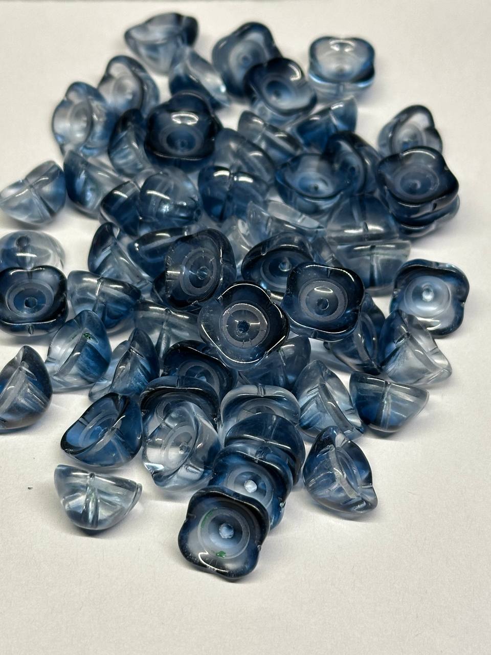 Blue bead caps scattered on a white surface