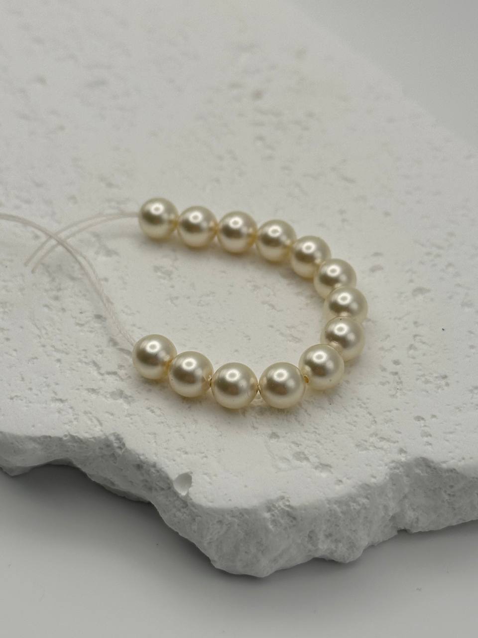 Creamrose crystal pearls on a textured stone surface