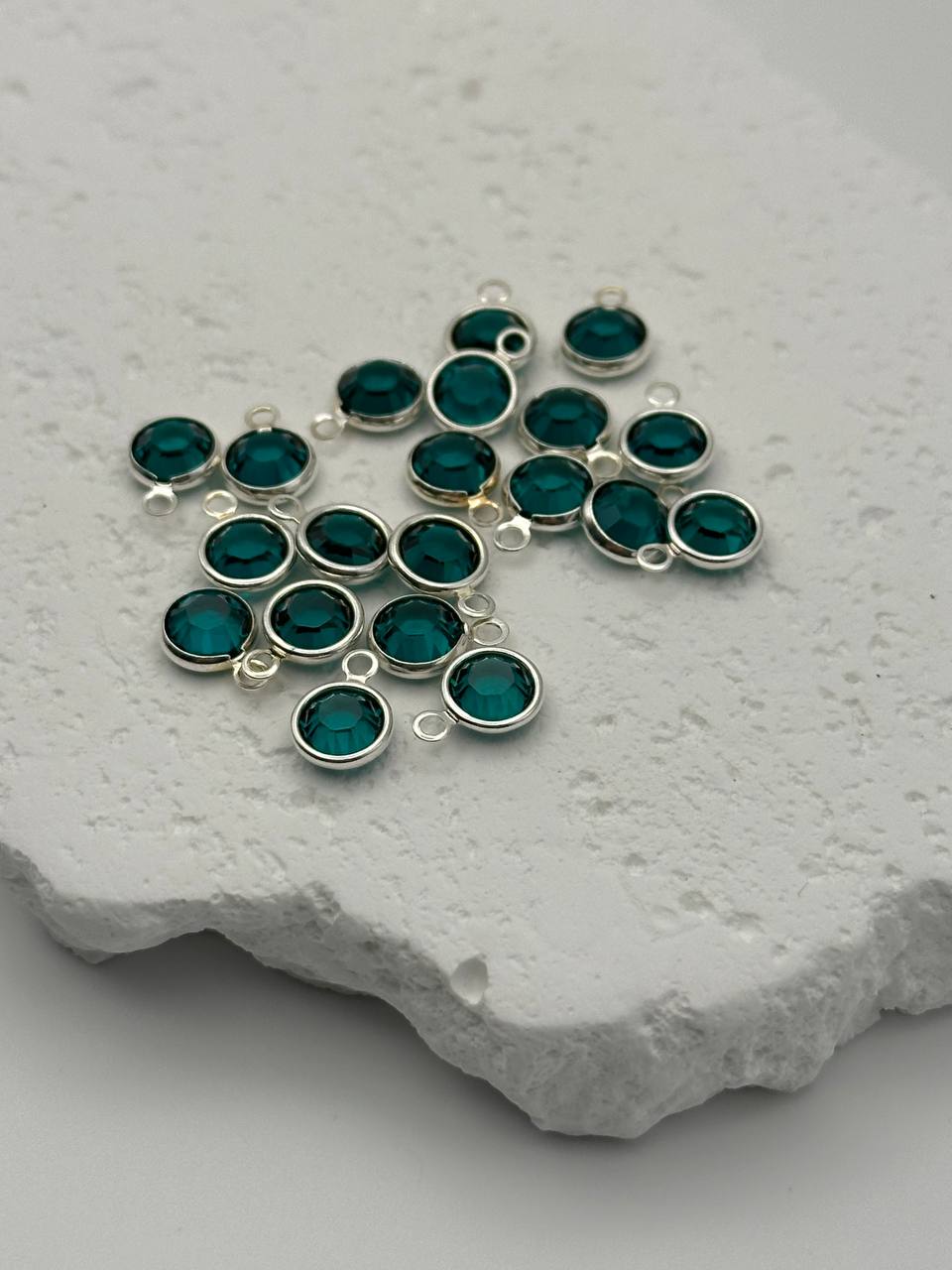 Emerald channel charms on white surface