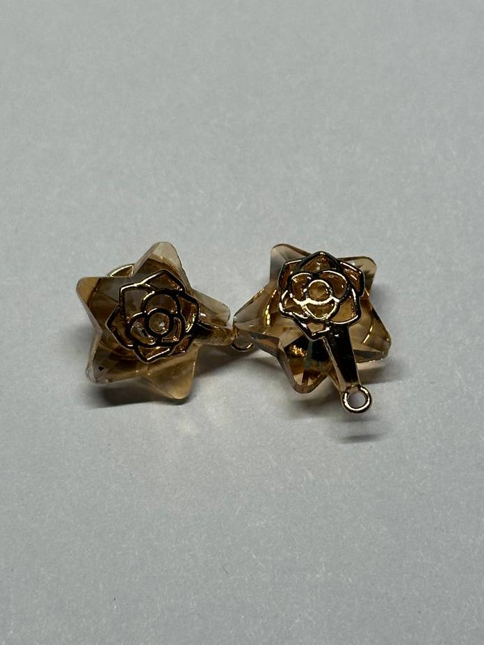 Gold rose-shaped charms on a light gray background