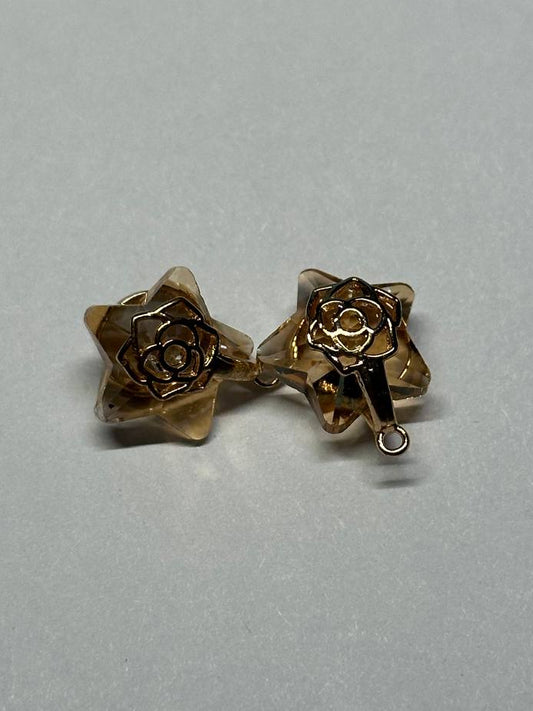 Gold rose-shaped charms on a light gray background