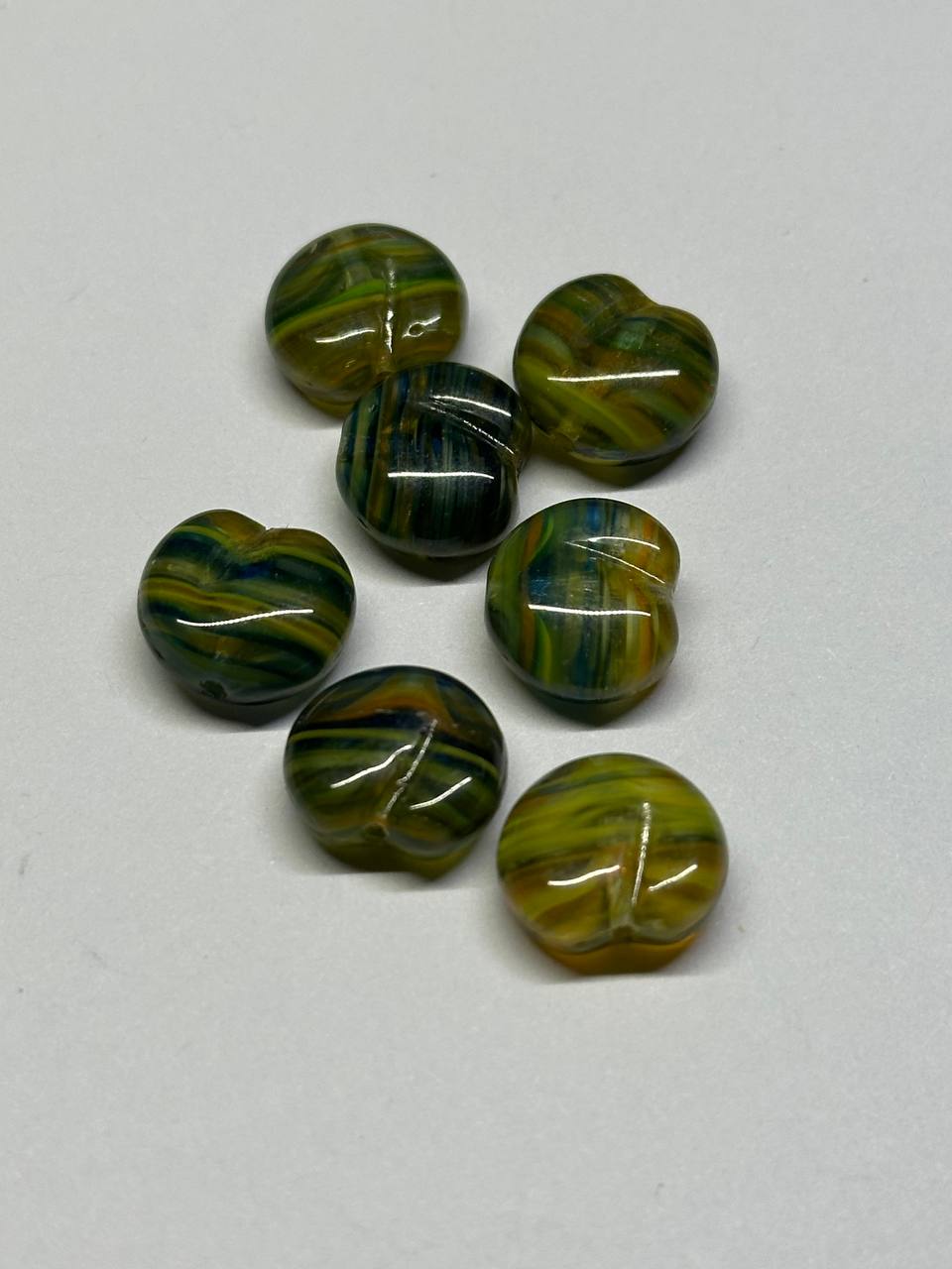 Set of green and brown striped beads on a white background